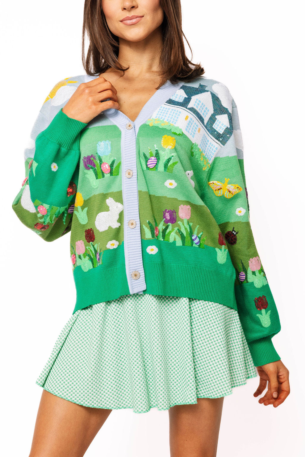 Woman wearing a green cardigan with floral patterns on a white background